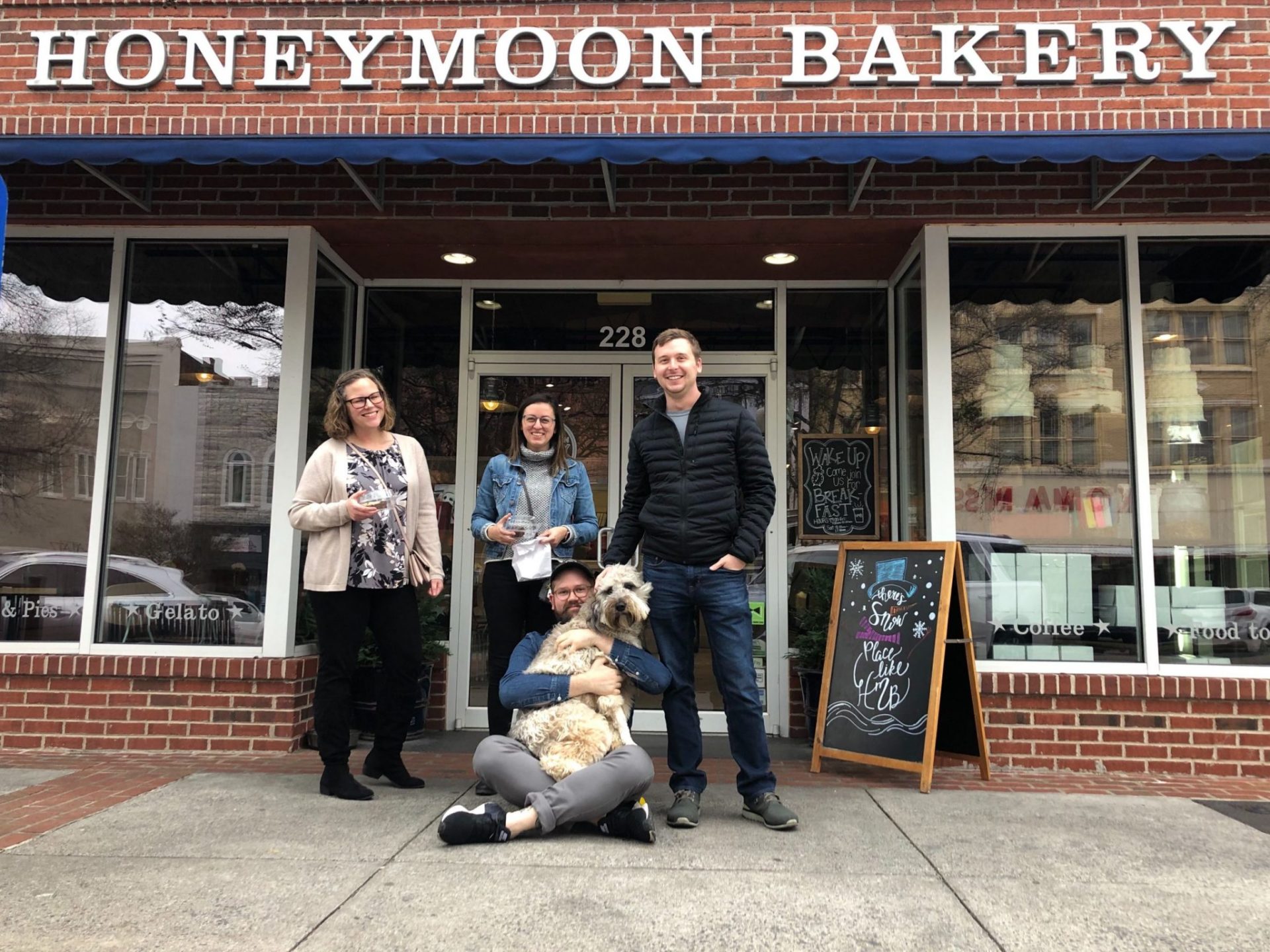 The Romega team, plus dog, poses outside Honeymoon Bakery