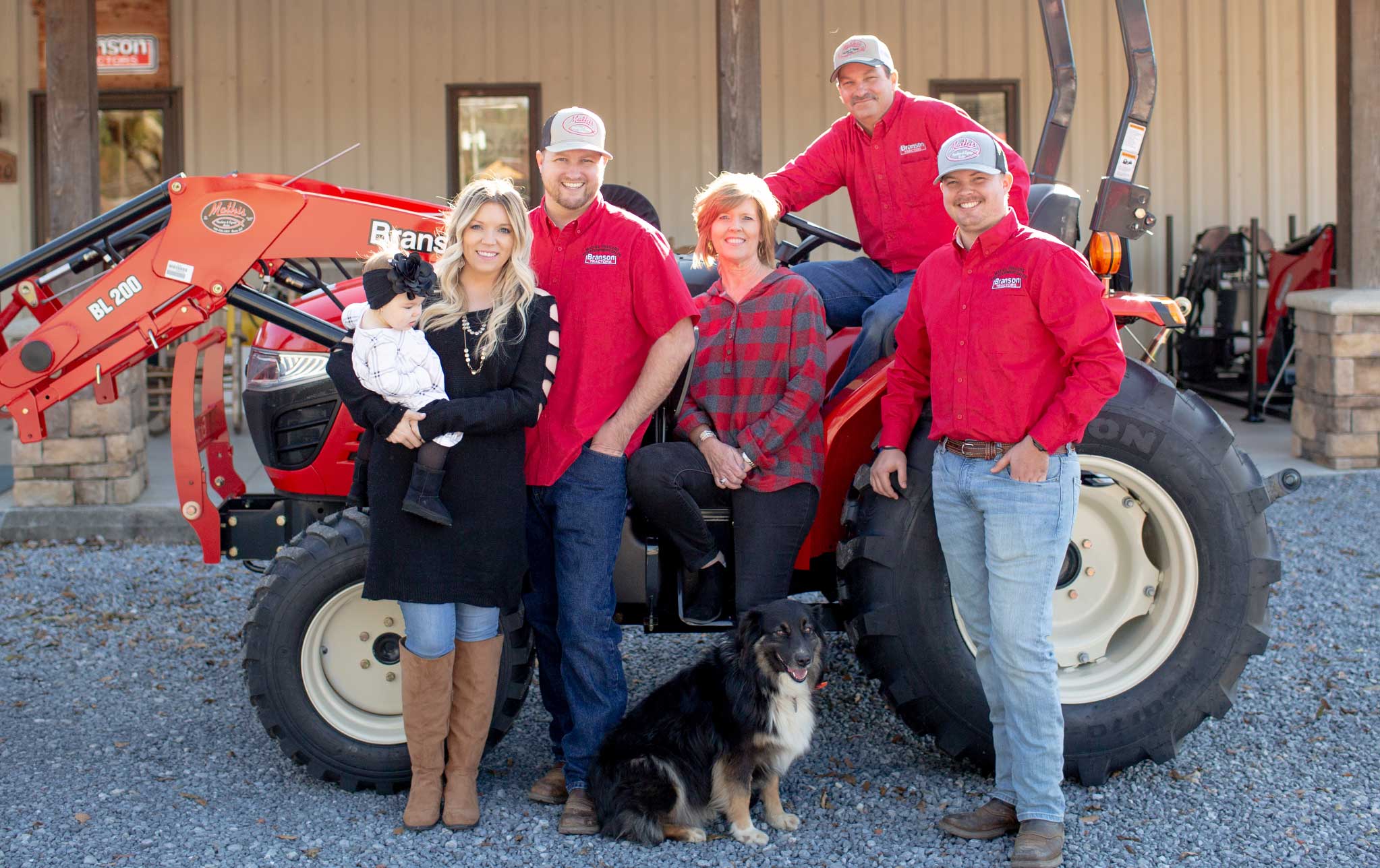 The Mathis family stands in front of a tractor